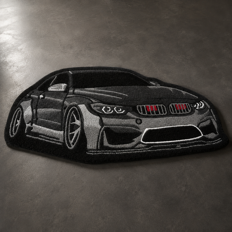 Black hand-tufted car rug shaped like a modern German coupe, on a grey floor