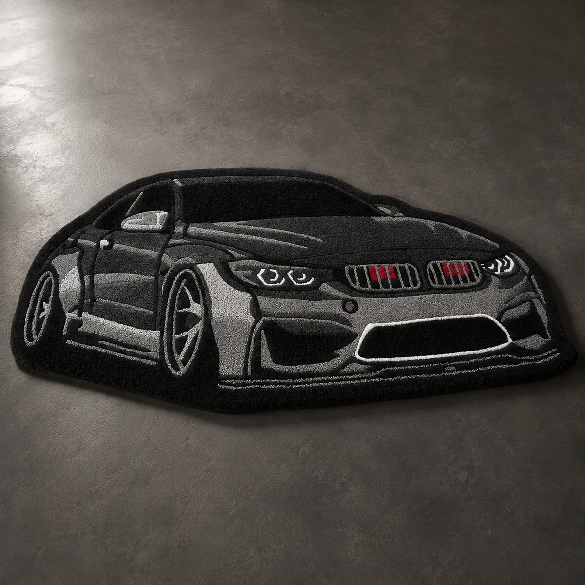 Black hand-tufted car rug shaped like a modern German coupe, on a grey floor