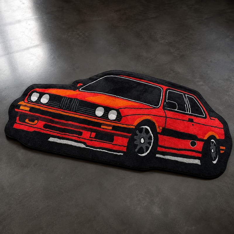 Orange and red hand-tufted car rug shaped like a boxy 1980s European coupe